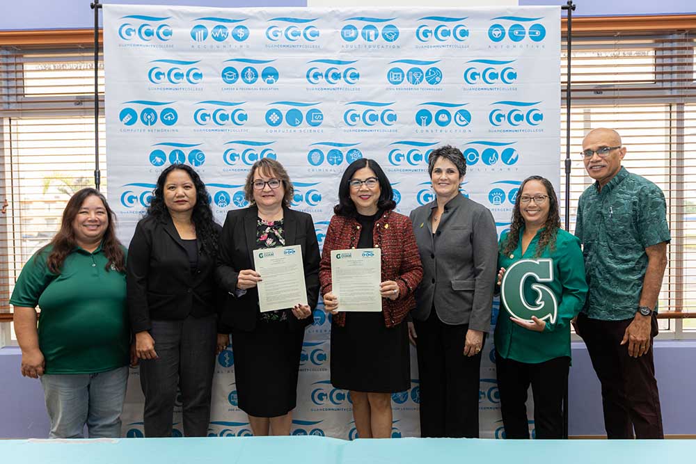 Photo of seven administrators holding a signed agreement